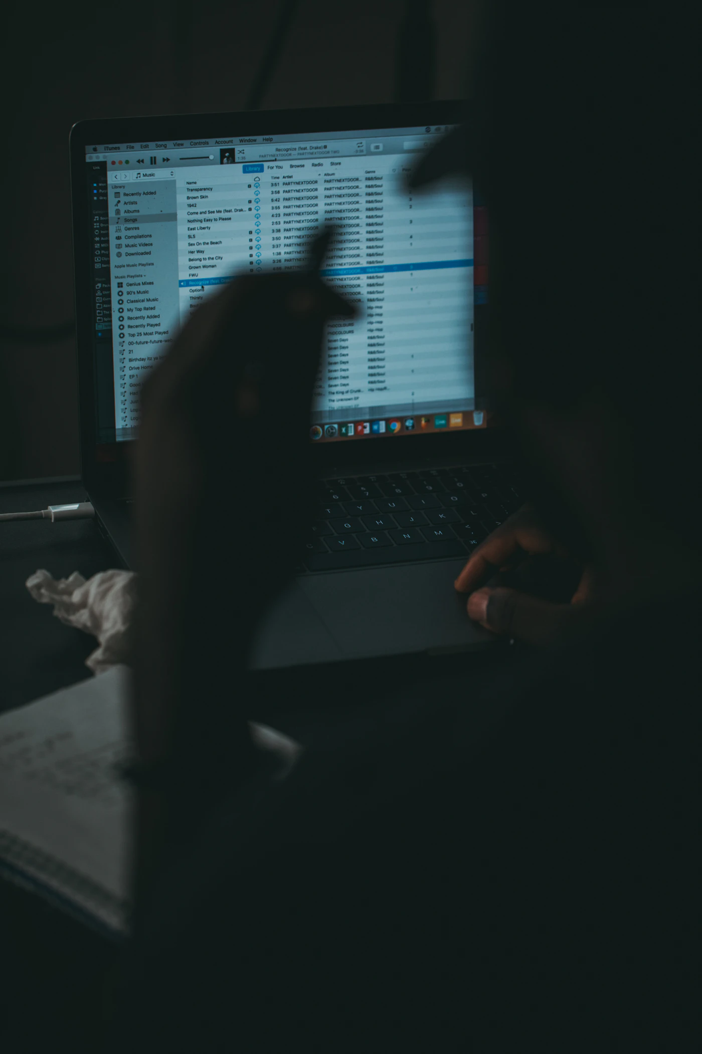 Silhouette d'une personne devant un ordinateur portable dans le noir
